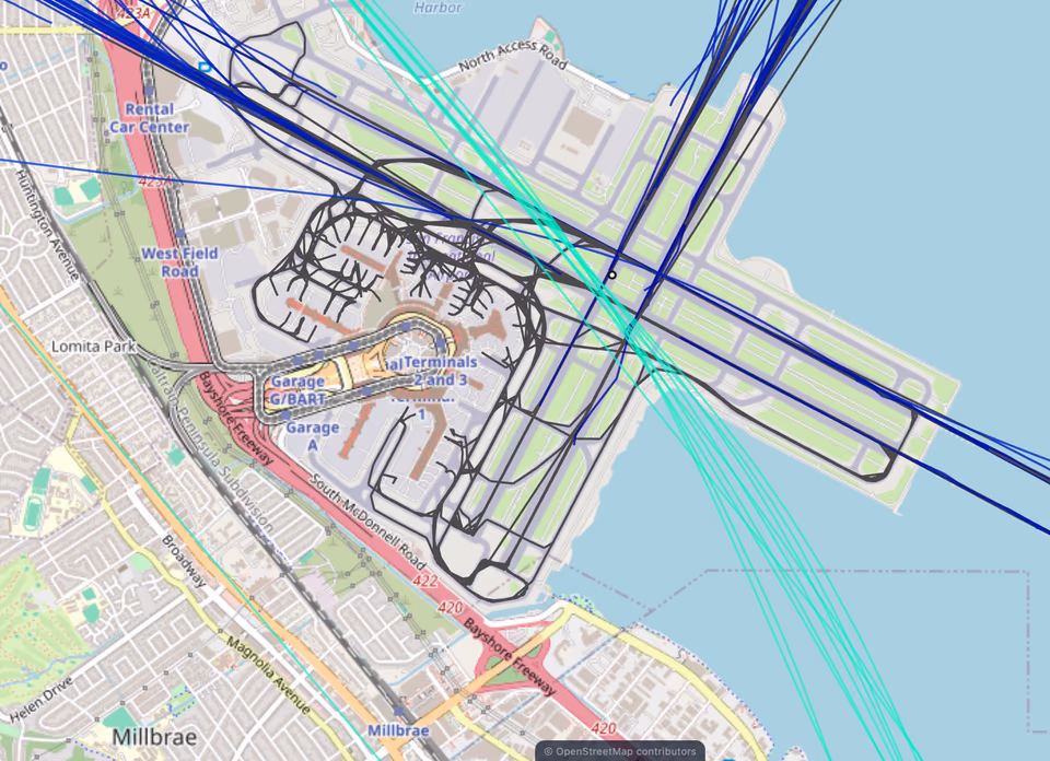 SFO zoomed to the taxiways, with black ground tracks tracing taxi paths between the gates and runways while arrival and departure tracks cross overhead